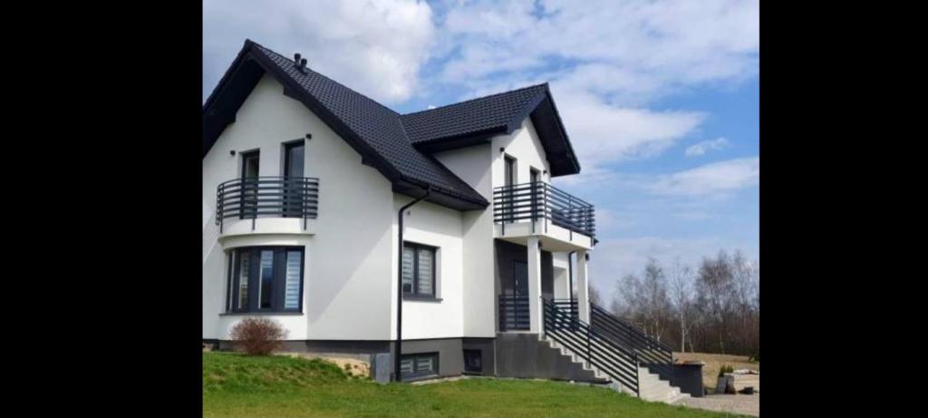 凯尔采Dom u Grzegorza的黑色屋顶的白色房子