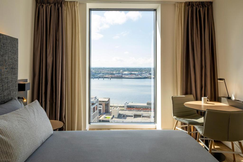 利物浦INNSiDE by Meliá Liverpool的一间卧室设有大窗户,享有水景