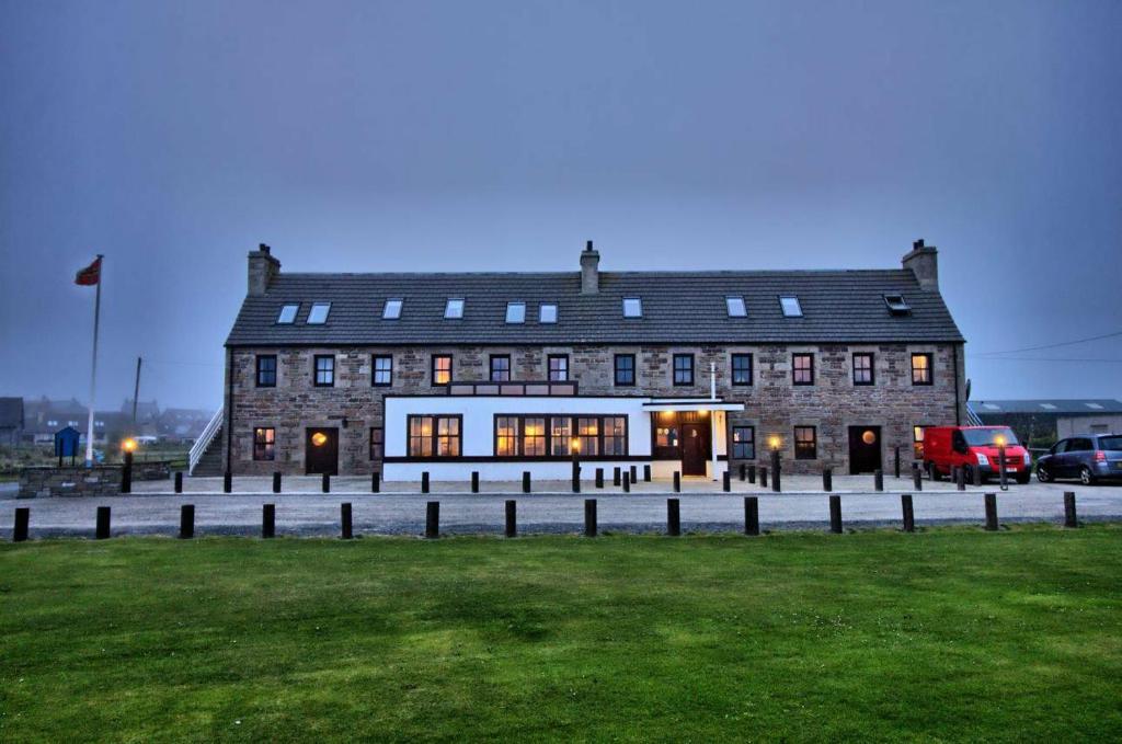 布里村The Sands Hotel, Orkney的前面有草坪的大型砖砌建筑