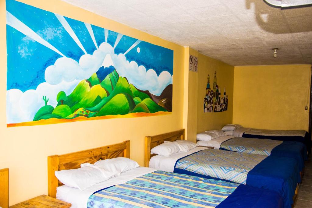拉塔昆加La Posada Del Viajero的墙上画画的房间里设有两张床