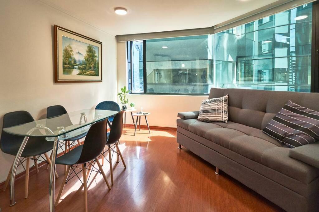 基多QuitoSuite Amoblada ubicación privilegiada的带沙发和玻璃桌的客厅
