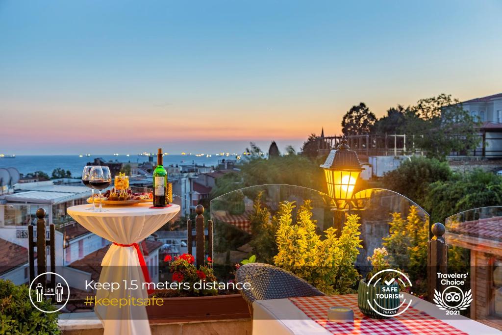 伊斯坦布尔老城最佳地段酒店 - 最佳团体酒店的阳台配有桌子和2瓶葡萄酒
