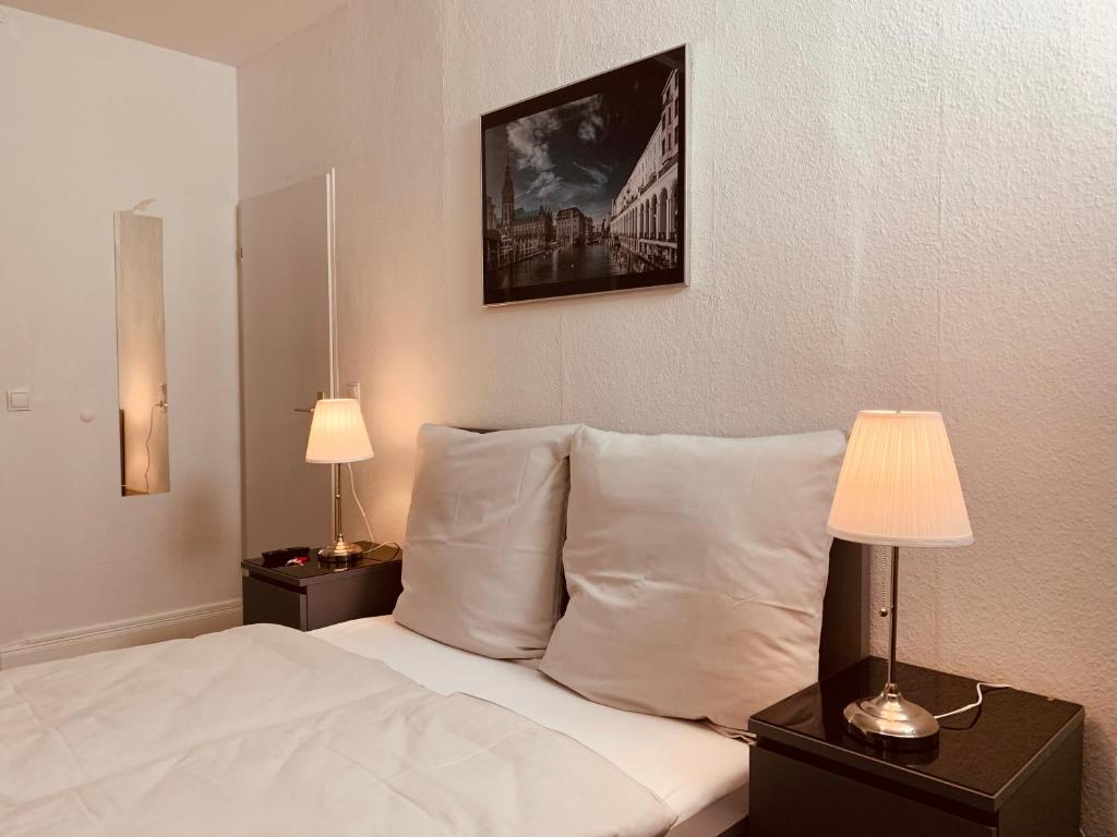 汉堡Sleep In Hamburg Kajüten的一间卧室配有一张带枕头的床和两盏灯。