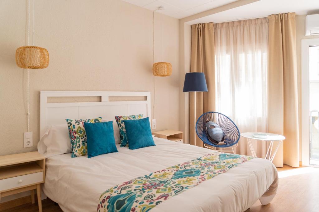 圣安东尼奥·德·卡隆Hotel Aubí的卧室配有带蓝色枕头的大型白色床