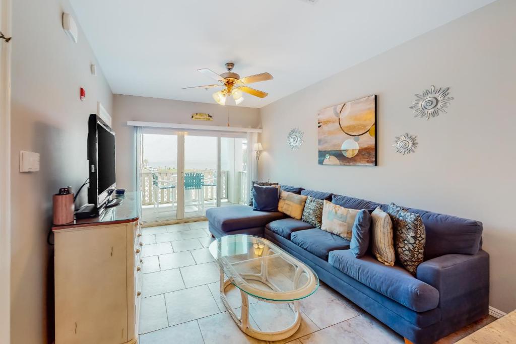 彭萨科拉海滩Baywatch G1的客厅配有蓝色的沙发和电视