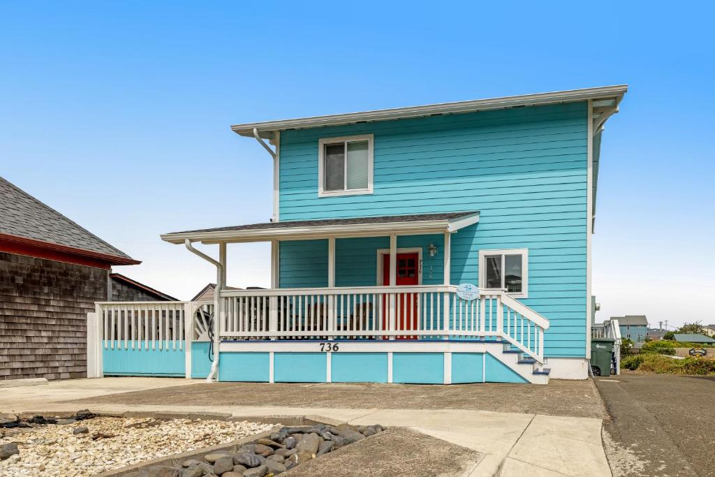新港Sea Mist Cottage的蓝色房子,设有白色甲板