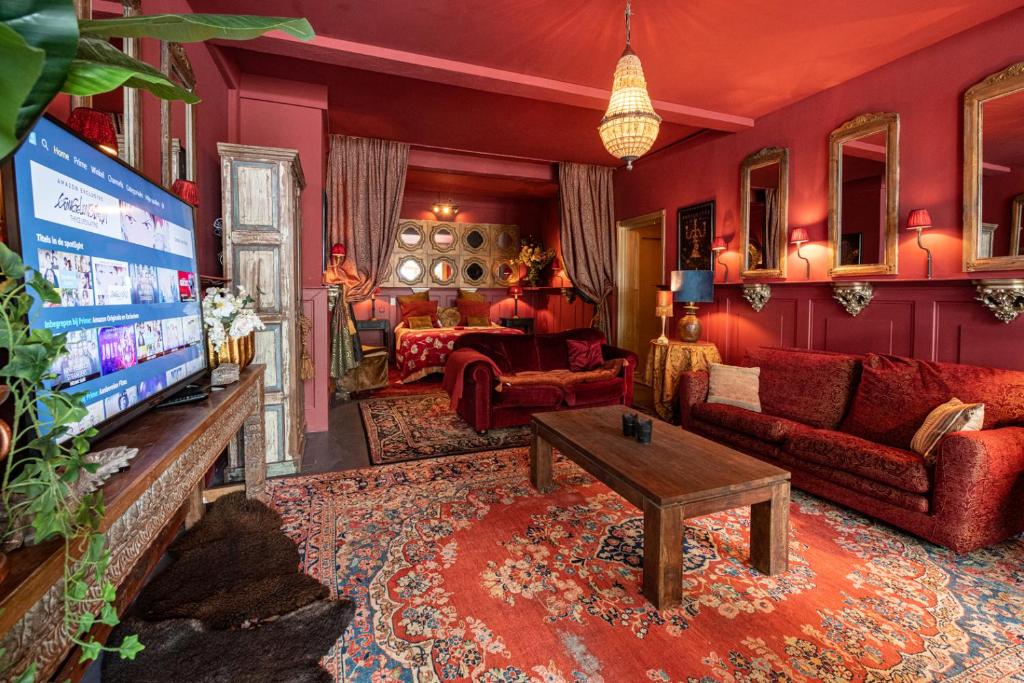 Vuren斯万酒店的客厅配有红色家具和电视