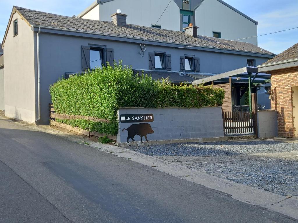 Bertognele sanglier的一只狗站在房子前面的标志旁
