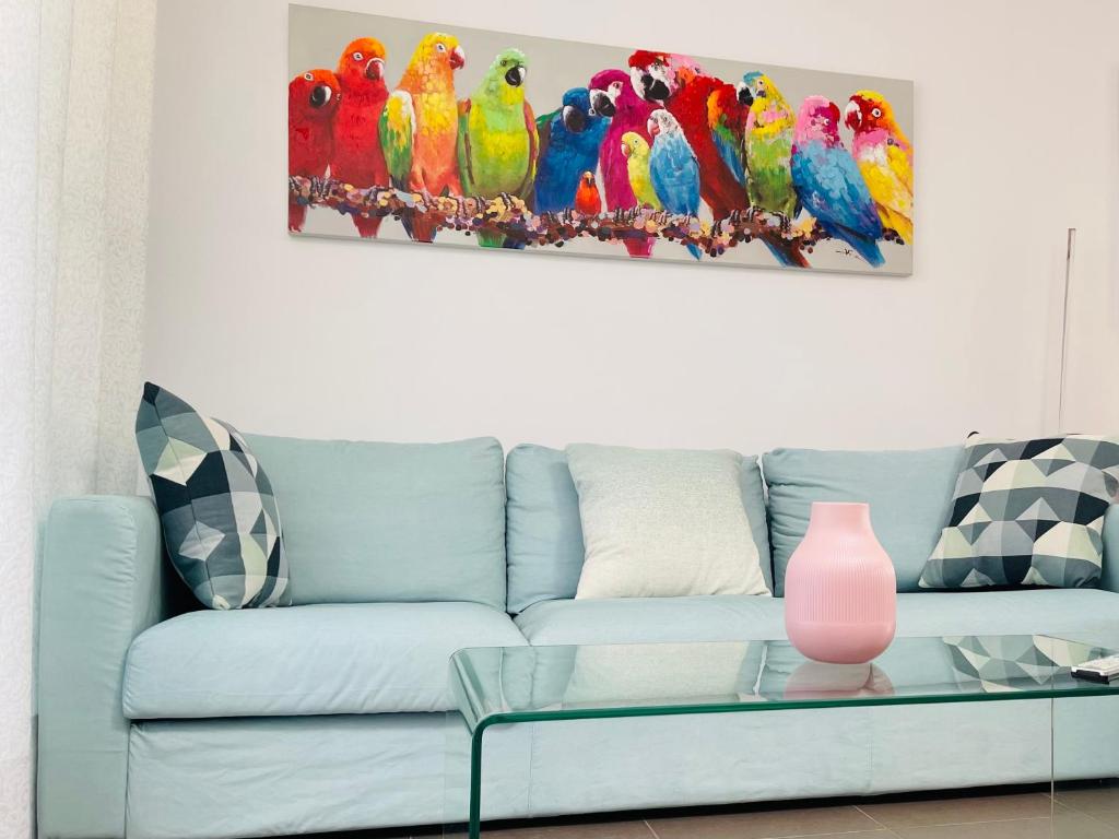 桑卢卡尔-德巴拉梅达Sunny Sanlucar的客厅配有带鹦鹉画的蓝色沙发