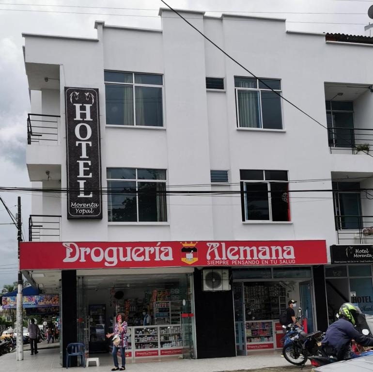 约帕尔hotel villa morenta的白色的建筑,带有红色标志的商店