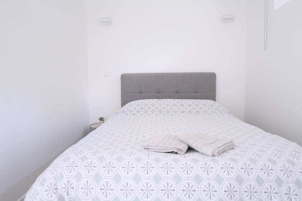 奥赛A la meulière d'Orsay, vue sur la vallée, au calme的一张白色的床,上面有两个白色的枕头