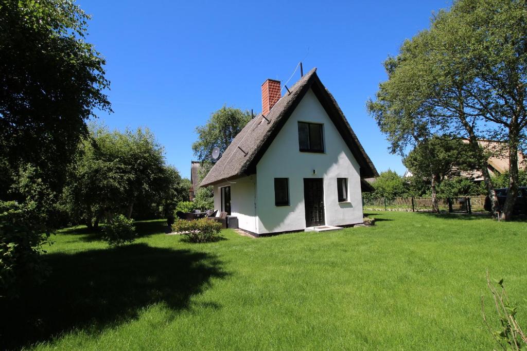 欧巴德伍斯图Reethaus Ostseestrand 15的白色的小房子,带有茅草屋顶
