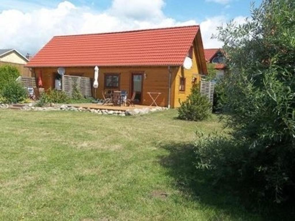 克林克Ferienhaus Bliev-Hee Nr 3的一座带红色屋顶和庭院的小房子