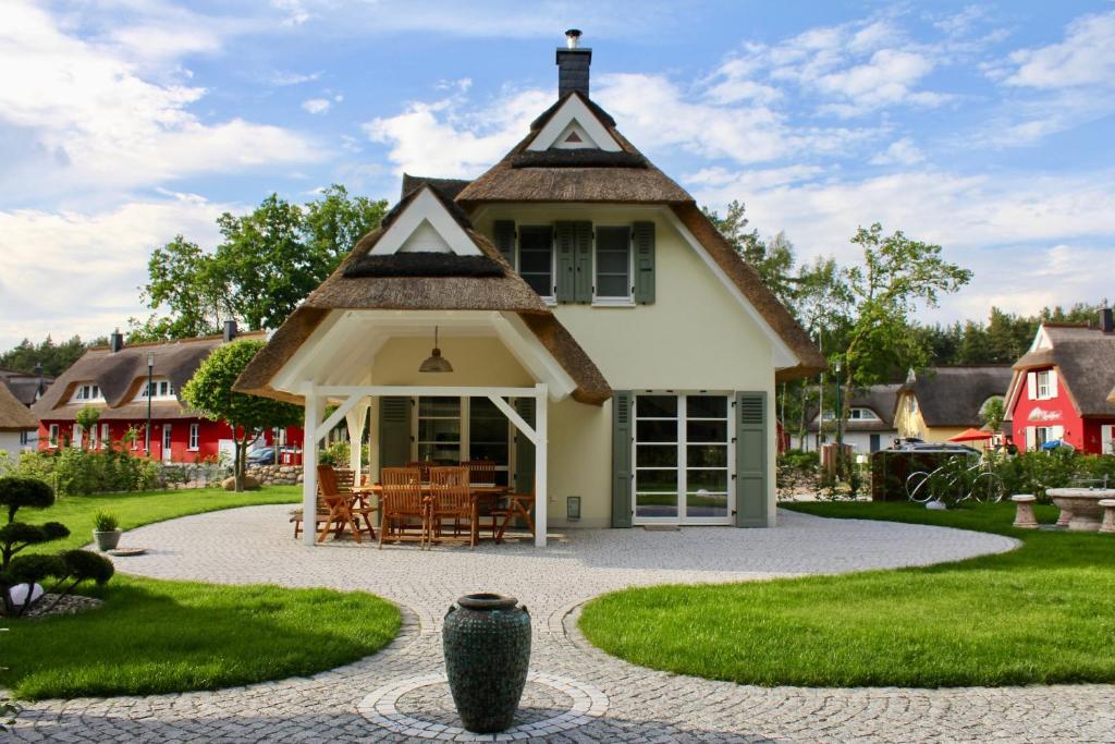格洛韦Ferienhaus Zeitlos的茅草屋顶和庭院的房子