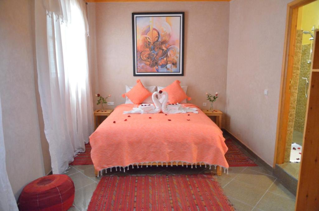 索维拉Riad Essaouira的一间卧室配有一张带橙色毯子的床
