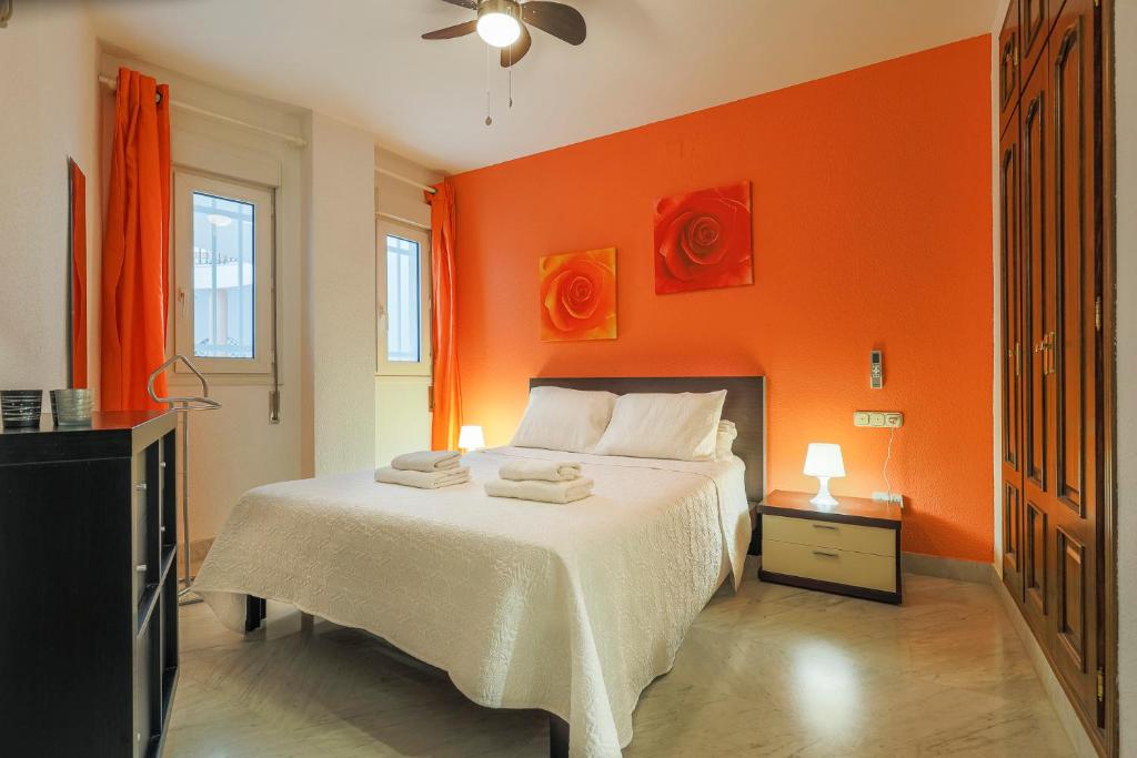 隆达Apartamentos Alameda del Tajo I Parquing Centro的一间卧室设有橙色的墙壁和一张带毛巾的床