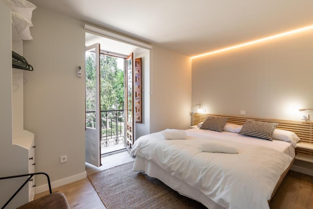 托莱多ToledoRooms VistaPark - Suites的卧室设有一张白色大床和一扇窗户。