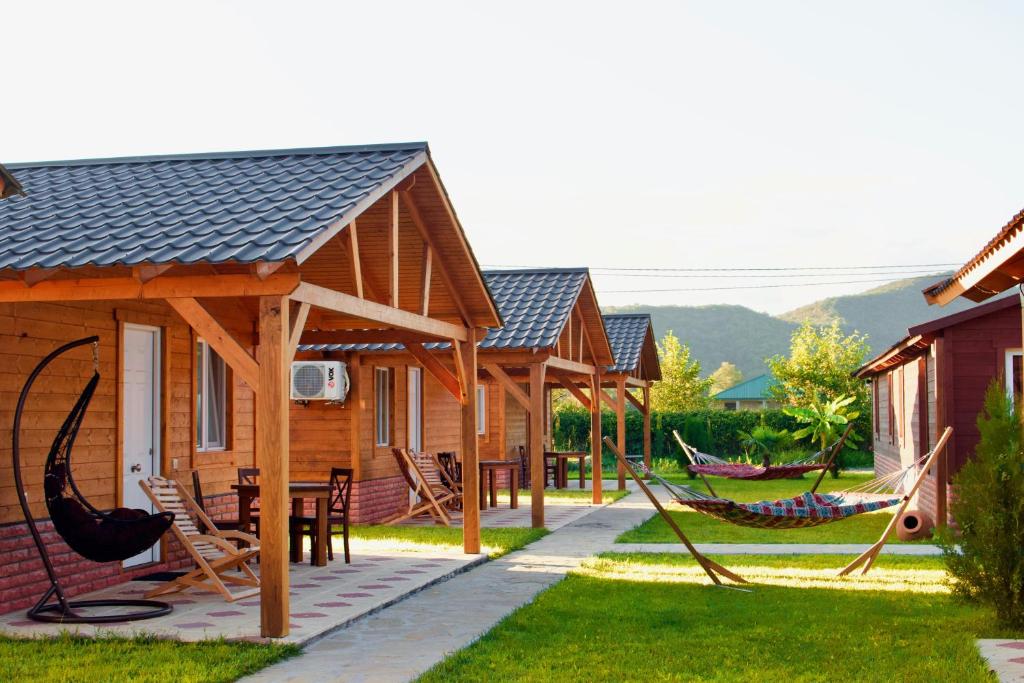 AkhmetyFinca Idoize Camping Hotel的庭院内一组带吊床的小屋