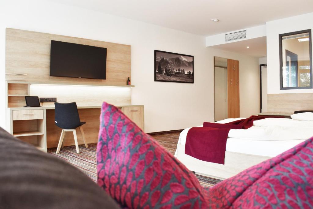 肯普滕Soloplan City Resort的一间酒店客房,配有一张床和一台电视