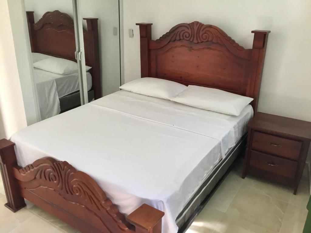 博卡奇卡Aparthotel El Sol, Home near AirPort SDQ的一间卧室配有一张大木床和镜子