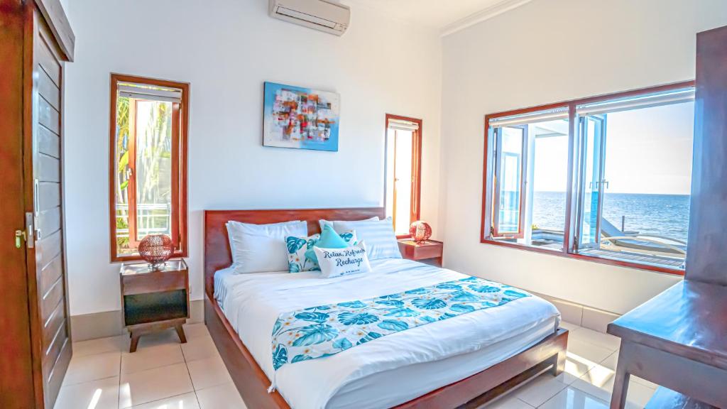 Kubutambahan爱萨尼海滩别墅的一间卧室设有一张床,享有海景
