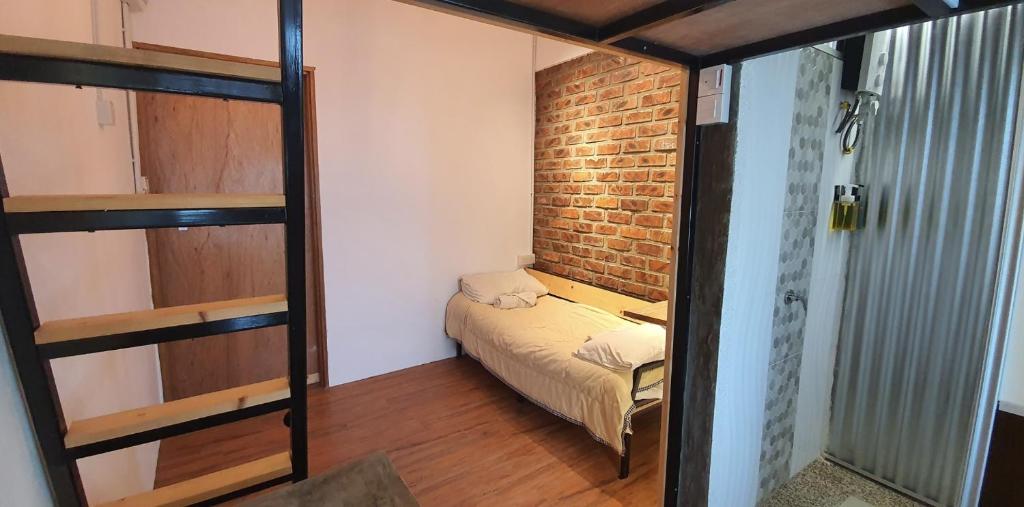 米里Tiny Home的小房间,设有床和砖墙