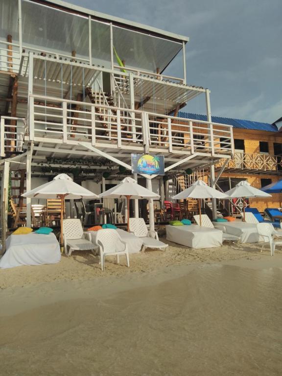 巴尔posada donde Uriel Playa tranquila的海滩上的一组椅子和遮阳伞