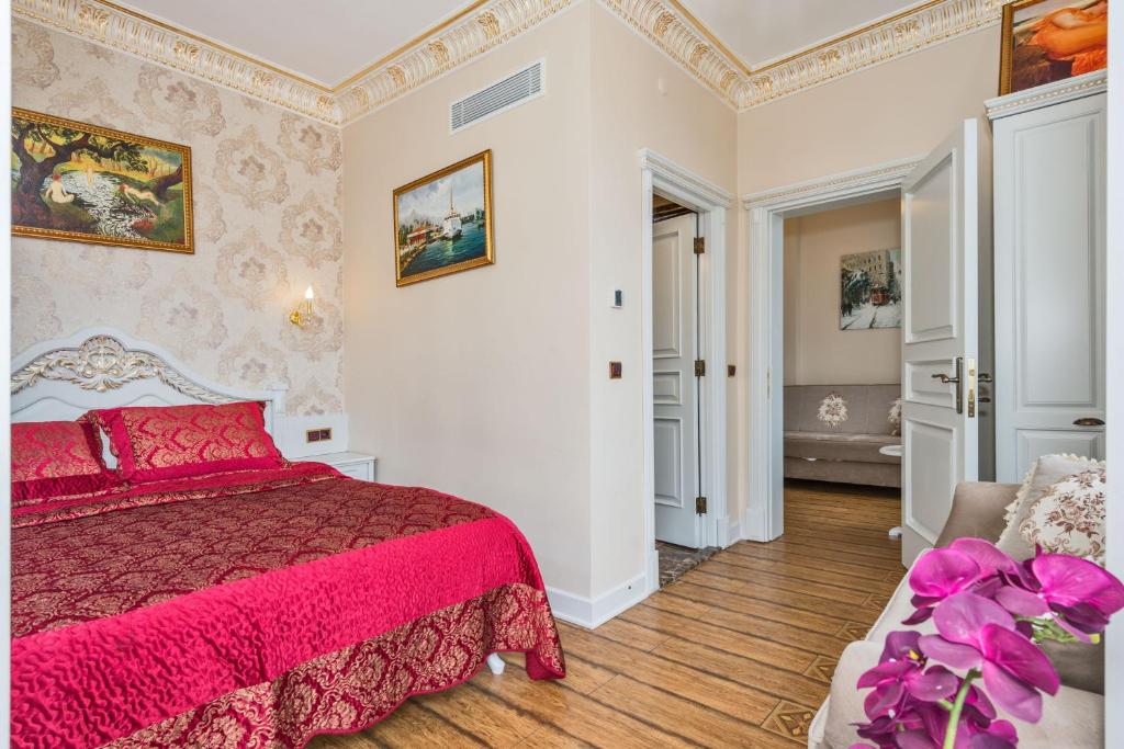 伊斯坦布尔IQ公寓式酒店的一间卧室配有红色的床和一张沙发