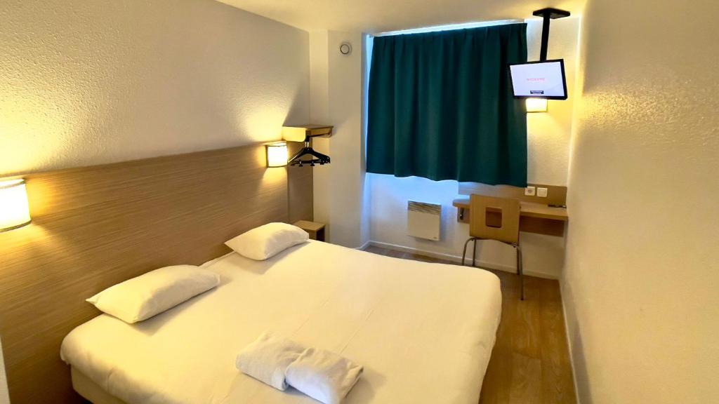 鲁瓦西昂法兰西CYAN HOTEL - Roissy Villepinte Parc des Expositions的一间酒店客房,配有一张白色的床和一张书桌