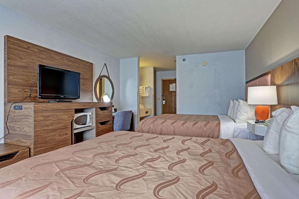 皮埃尔Quality Inn Pierre-Fort Pierre的酒店客房设有两张床和一台平面电视。