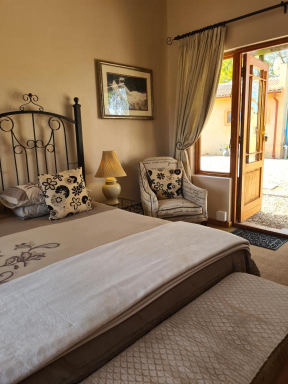 阿多卡萨米亚健康水疗及旅馆的一间卧室配有一张大床和一把椅子
