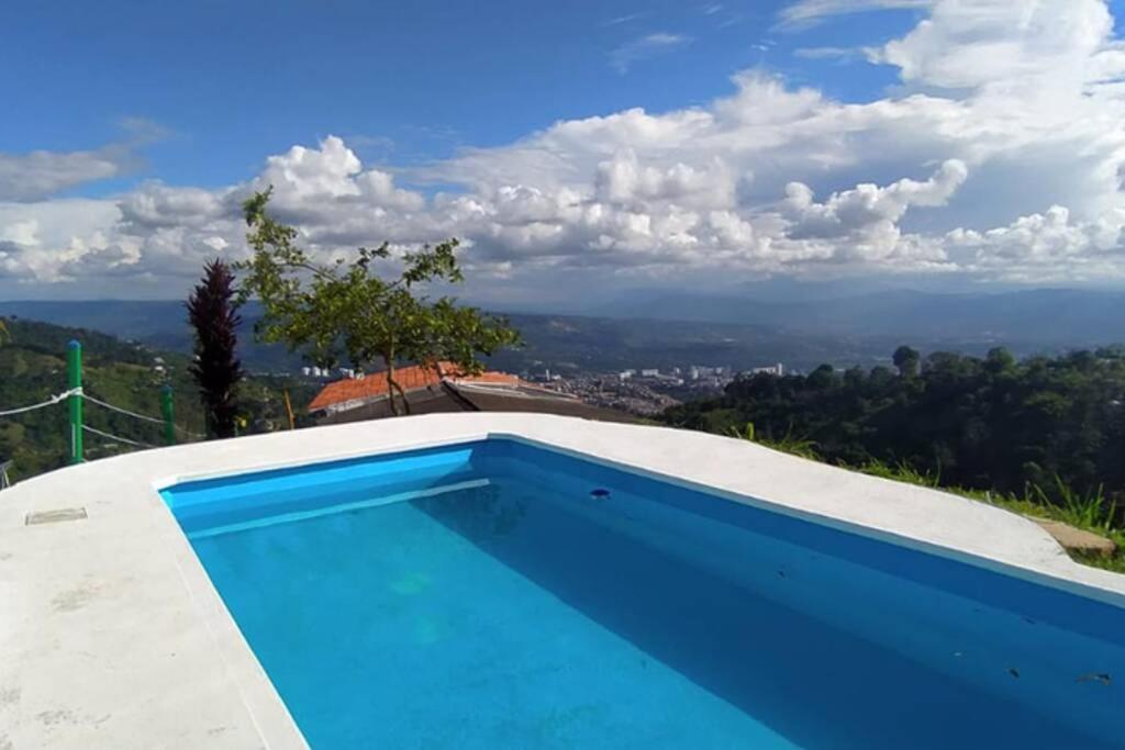 布卡拉曼加Hermosa finca con vista a la ciudad a 20 min de Bucaramanga的房屋一侧的游泳池