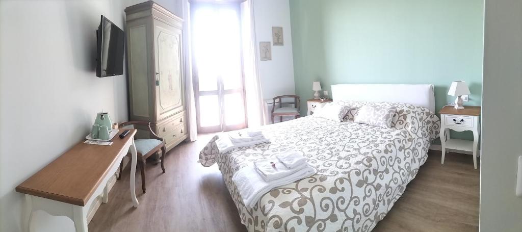 蒙扎Al Giardino Segreto的一间卧室配有一张床、一张书桌和一台电视