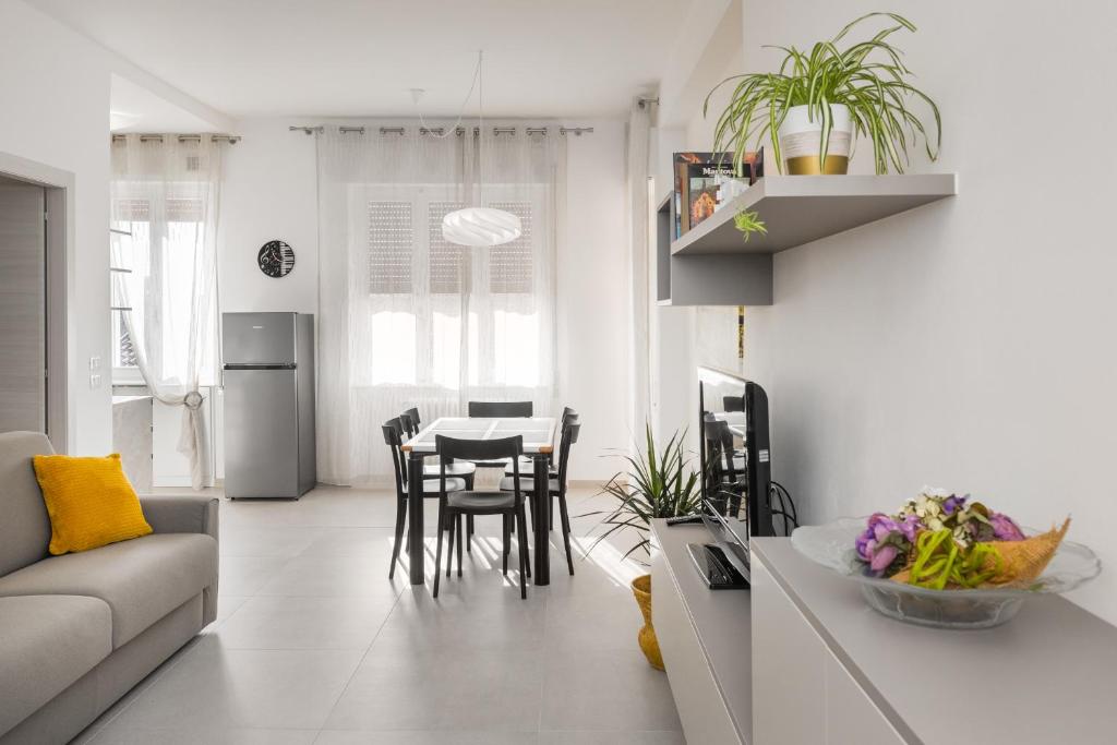 维罗纳Civico40 Luminoso appartamento con balconi e garage privato的厨房以及带沙发和桌子的客厅。