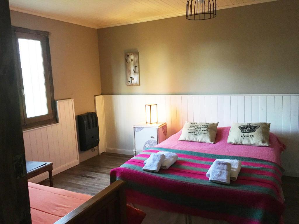 拉斯弗洛雷斯Casa de Campo La Colorada的一间卧室配有粉红色的床和毛巾