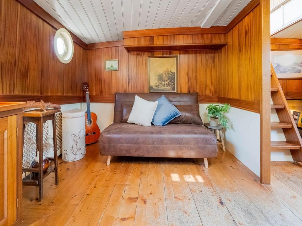 KerkdrielLuxury boat in Kerkdriel的带沙发和吉他的客厅
