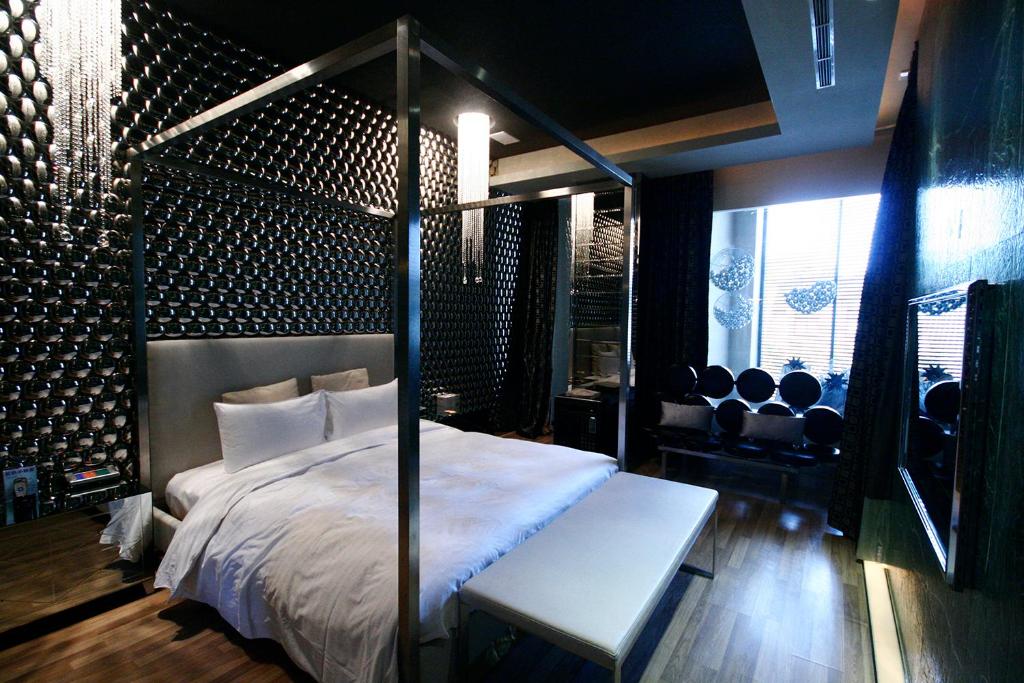 桃园市约客顶级汽车旅馆的一间卧室配有一张天蓬床、长凳和椅子