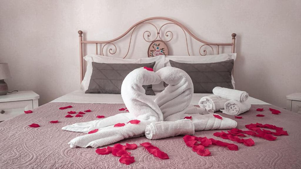 阿尔贝罗贝洛"B&B La Lanterna" Trulli & Dimore Storiche的两个天鹅用毛巾制成的,放在玫瑰床上