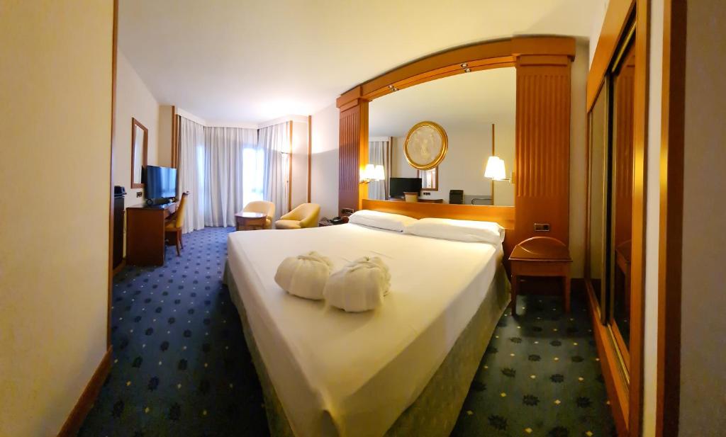 洛格罗尼奥Hotel los Bracos的酒店客房带一张大床,上面有两条毛巾