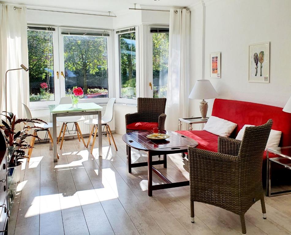 汉堡Hamburg Niendorf-Suite的客厅配有红色的沙发和桌子