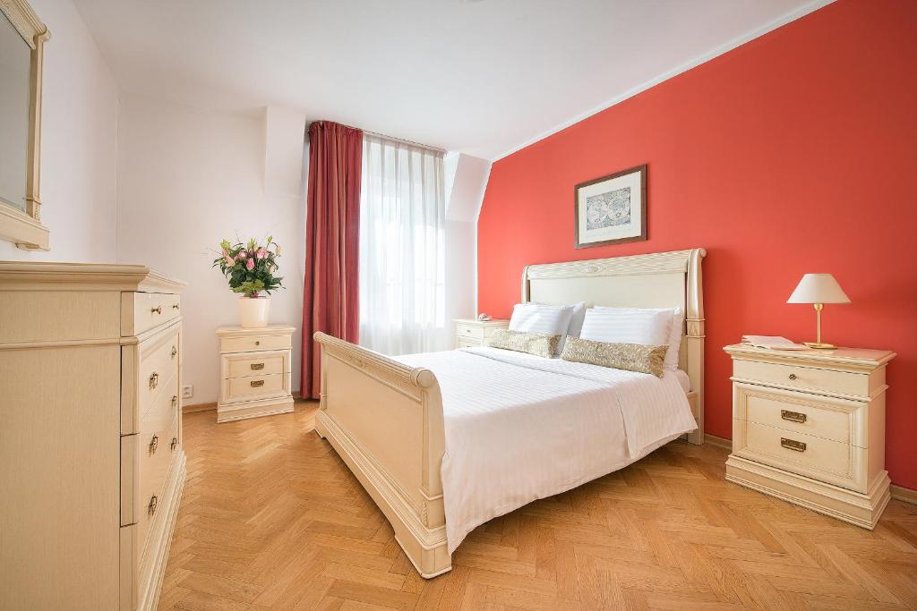 布拉格布拉格公寓酒店的卧室配有白色的床和红色的墙壁