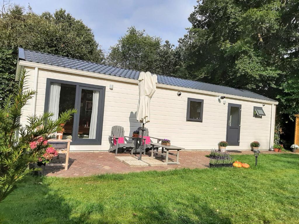 沃尔夫海泽De Woudtplaats的白色的小房子,配有野餐桌和椅子