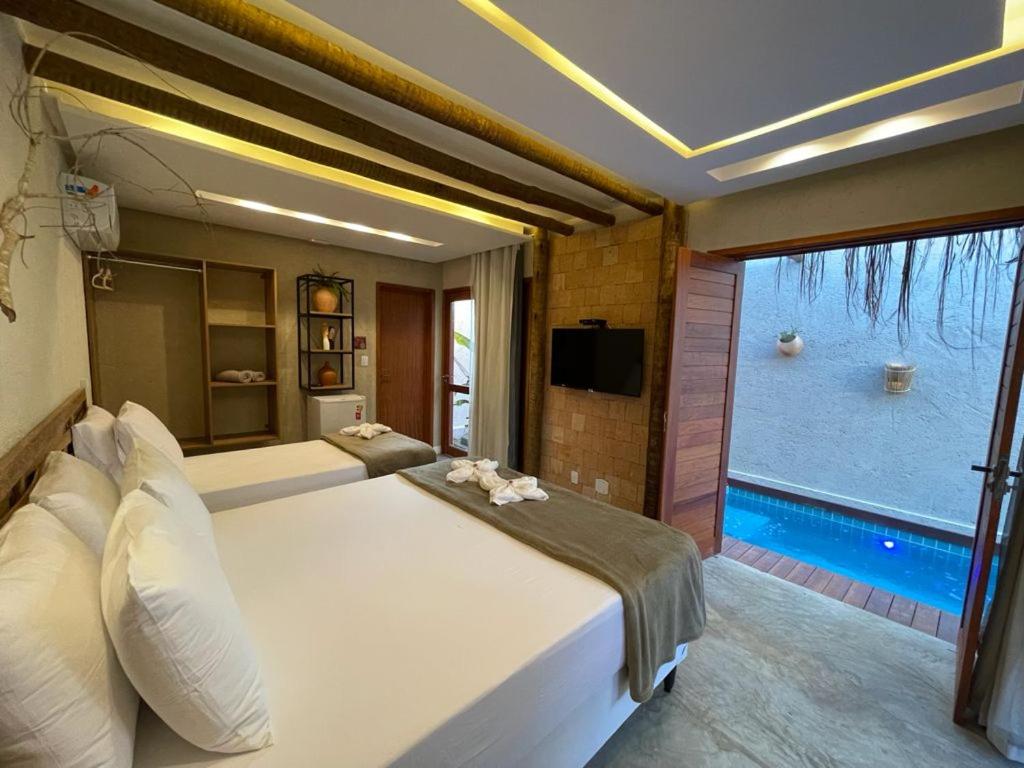 圣米格尔-杜斯米拉格里斯Naim Milagres的一间带大床的卧室和一个游泳池