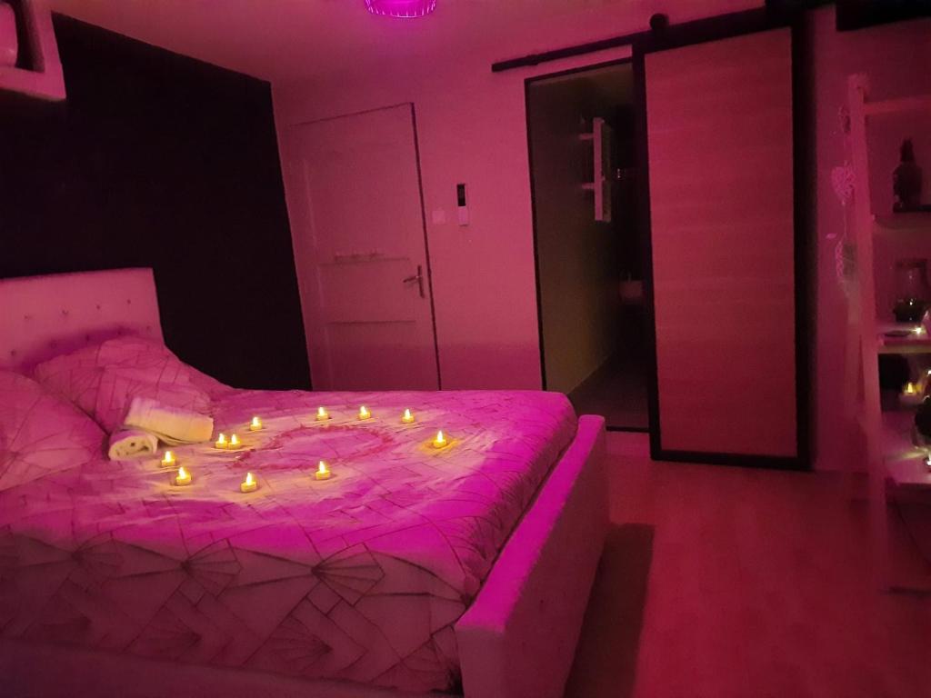 Saint-Mitre-les-RempartsMaison avec jacuzzi的粉红色的卧室,配有一张带蜡烛的床