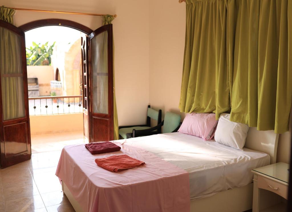 卢克索DREAM ISLAND Hotel的一间卧室配有一张带窗户和椅子的床