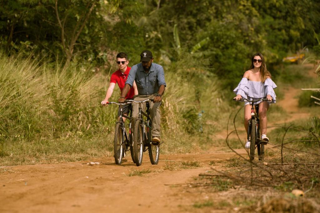 达瓦拉维大象足迹酒店的三人骑着自行车在土路上