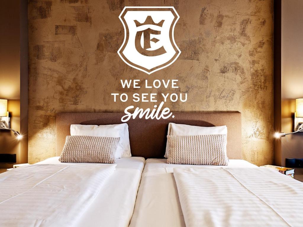 伊姆斯特Stadthotel EGGERBRÄU的卧室配有一张挂有纹身标志的床