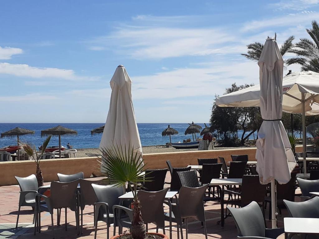 圣路易斯·德·萨比尼尔Centro Playa de Sabinillas Manilva的一排桌椅,带遮阳伞,享有海景