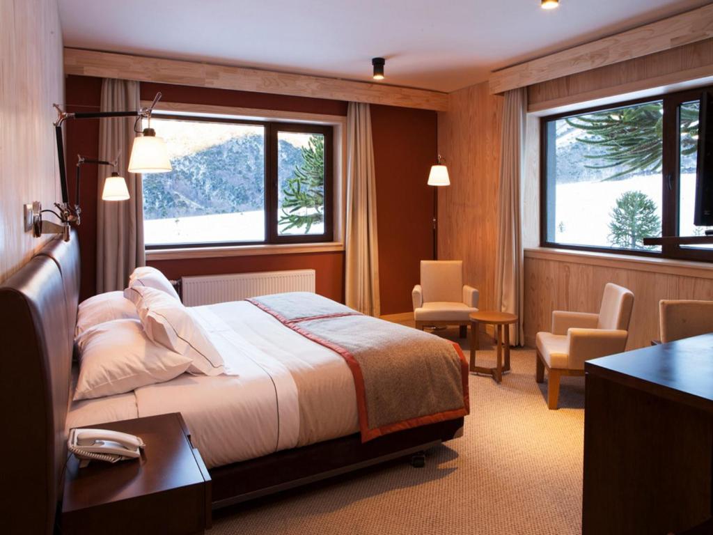 马拉卡韦罗科拉尔克谷Spa酒店的一间卧室配有一张床、一张书桌和两个窗户。