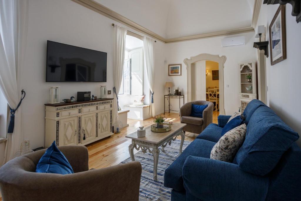埃尔瓦斯Casa do Povo的客厅配有蓝色的沙发和电视
